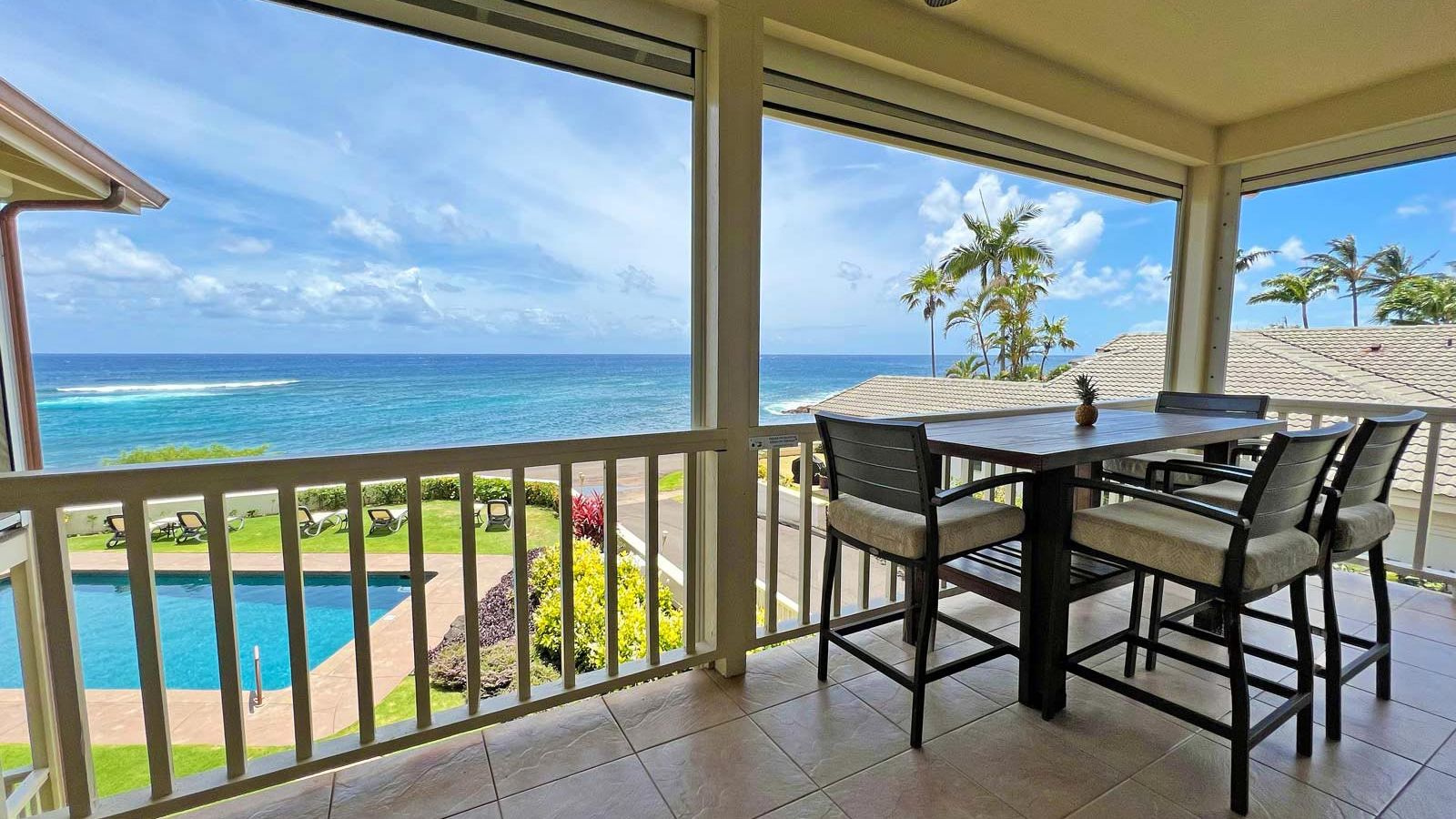 large tiled second floor lanai with bar-height dining set overlook oceanfront pool