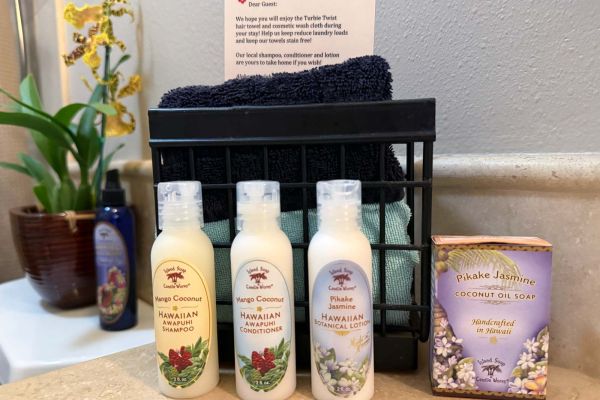 bathroom amenities include fresh orchid, makeup cloth, hair turban, and bath products from Island Soap and Candle Works