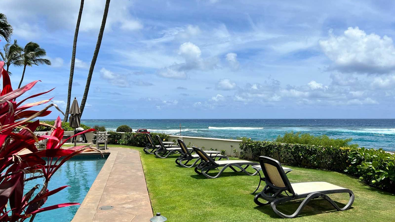 Alihi Lani vacation rental condo oceanfront pool with comfortable lounge chairs on the grass